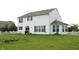Spacious backyard features a large well-maintained lawn, a white picket fence, and the home's exterior at 8519 Frosty Rose Dr, Avon, IN 46123