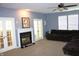 Carpeted living room with fireplace, ceiling fan, and natural light from the windows and glass panel doors at 8519 Frosty Rose Dr, Avon, IN 46123
