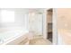 Bright bathroom featuring a tub, shower, walk-in closet, and tile flooring at 9220 Crossing Dr, Fishers, IN 46037