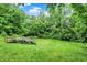 Private backyard with lush greenery, mature trees, and a charming wood stairway at 9302 Budd Run Dr, Indianapolis, IN 46250