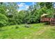 Large backyard with a deck and stairs surrounded by mature trees at 9302 Budd Run Dr, Indianapolis, IN 46250