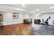 Finished basement area featuring wood-look floors, a gray sofa, and a home gym at 9302 Budd Run Dr, Indianapolis, IN 46250
