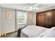 This bedroom features a window, a ceiling fan, carpet, and a closet with wood doors at 9302 Budd Run Dr, Indianapolis, IN 46250