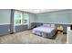 Comfortable bedroom featuring blue walls, plush carpet, and a large window for natural light at 9302 Budd Run Dr, Indianapolis, IN 46250