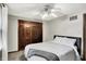 This bedroom has carpet, a ceiling fan, a window, and a closet with dark, wooden, by-pass doors at 9302 Budd Run Dr, Indianapolis, IN 46250