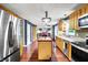 Bright kitchen with wood cabinets and island providing access and views to other rooms in an open floor plan at 9302 Budd Run Dr, Indianapolis, IN 46250