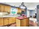 Bright kitchen featuring wood cabinets, an island with red countertop, stainless steel appliances, and stylish mosaic backsplash at 9302 Budd Run Dr, Indianapolis, IN 46250