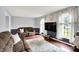 Comfortable living room with hardwood floors, large windows, and a recliner sofa at 9302 Budd Run Dr, Indianapolis, IN 46250