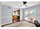 View of office showcasing a desk, ceiling fan, blue walls and direct access to the kitchen area with wood floors at 9302 Budd Run Dr, Indianapolis, IN 46250