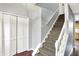Carpeted staircase with white railing and hardwood floors, leading to the upper levels of the home at 9302 Budd Run Dr, Indianapolis, IN 46250
