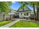 Private, fenced backyard with a patio perfect for outdoor seating, complemented by lush greenery and a dog house at 938 N Tuxedo St, Indianapolis, IN 46201