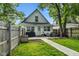 Private, fenced backyard with a patio perfect for outdoor seating, complemented by lush greenery and a dog house at 938 N Tuxedo St, Indianapolis, IN 46201