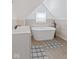 Modern bathroom featuring a freestanding tub, sink, modern fixtures, and neutral tile at 938 N Tuxedo St, Indianapolis, IN 46201
