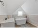 A modern bathroom featuring a freestanding tub, a sink, and a bright window at 938 N Tuxedo St, Indianapolis, IN 46201