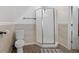 A bathroom featuring a toilet, a stall shower with frosted glass, and wood look flooring at 938 N Tuxedo St, Indianapolis, IN 46201
