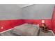 A cozy bedroom featuring soft gray carpeting, a bed with a neutral blanket, and a bright accent wall at 938 N Tuxedo St, Indianapolis, IN 46201