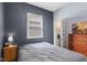 Cozy bedroom features a queen bed, window, dresser, and easy access to an adjoining bathroom at 938 N Tuxedo St, Indianapolis, IN 46201