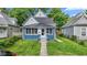 Charming home featuring a blue brick facade, inviting front porch, and well-maintained lawn at 938 N Tuxedo St, Indianapolis, IN 46201