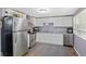 Eat-in kitchen with stainless steel appliances, white cabinetry, and durable countertops at 938 N Tuxedo St, Indianapolis, IN 46201
