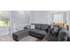 Cozy living room featuring a comfortable gray sofa sectional, neutral walls, and stairway at 938 N Tuxedo St, Indianapolis, IN 46201