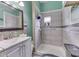 Bathroom featuring tiled shower with mosaic accent and vanity with framed mirror at 952 Lasalle St, Indianapolis, IN 46201