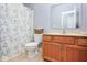 Well-lit bathroom features floral shower curtain, wooden vanity, and a neutral-colored countertop at 9682 Angelica Dr, Noblesville, IN 46060