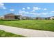 A fenced community pool is bordered by large manicured lawn and neighborhood homes under a bright blue cloudy sky at 9682 Angelica Dr, Noblesville, IN 46060