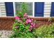 Lush front yard with colorful flowers and plants accentuating the brick foundation and home's charm at 9682 Angelica Dr, Noblesville, IN 46060