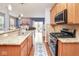 Kitchen featuring stainless steel appliances, wooden cabinets, granite countertops and view to the open-concept living room at 9682 Angelica Dr, Noblesville, IN 46060