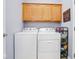 Functional laundry area with side-by-side washer and dryer and wooden cabinetry for ample storage at 9682 Angelica Dr, Noblesville, IN 46060