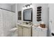 Well-lit bathroom features a decorative mirror, white cabinets, and a shower-tub combination at 9833 Parkshore Dr, Fishers, IN 46038