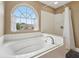 Bright bathroom showcasing a soaking tub with a large window and separate shower with white tile at 9833 Parkshore Dr, Fishers, IN 46038