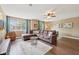 Inviting living room featuring a large sectional sofa, ceiling fan, and views from the bright windows at 9833 Parkshore Dr, Fishers, IN 46038