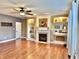 Bright living room featuring a fireplace, built-in shelving, and beautiful hardwood floors at 9833 Parkshore Dr, Fishers, IN 46038