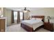 Bedroom features a large bed with a wooden frame, carpet, and two windows with curtains at 101 Meadowview Dr, Mooresville, IN 46158