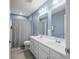 Neutral-colored bathroom with blue walls, tile floor, double sink, and neutral shower curtain at 1026 Woodglen Dr, Westfield, IN 46074