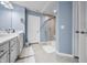 Neutral-colored bathroom with modern shower stall featuring glass door and white double sink at 1026 Woodglen Dr, Westfield, IN 46074
