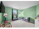 room with green walls, a small bed, a television, and space to play at 1026 Woodglen Dr, Westfield, IN 46074