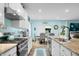 Well-lit kitchen showcasing granite countertops, stainless steel appliances, an island sink, and hardwood flooring at 1026 Woodglen Dr, Westfield, IN 46074