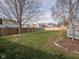 Green backyard features level lawn, wood fence perimeter, patio, and garden bed at 10443 Ringtail Pl, Fishers, IN 46038