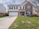 Charming two-story home with a well-manicured lawn, attached garage, and tasteful fall decorations at 10443 Ringtail Pl, Fishers, IN 46038