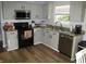 Well-lit kitchen with granite countertops, stainless steel appliances, and white cabinets at 10443 Ringtail Pl, Fishers, IN 46038