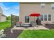 Cozy back patio featuring an outdoor seating area, red umbrella, and a privacy fence at 10515 Sugar Ridge Way, Indianapolis, IN 46239