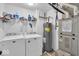 Functional laundry room with modern washer and dryer, along with essential water heater and storage at 10515 Sugar Ridge Way, Indianapolis, IN 46239