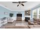 A bright living room with a fireplace, large windows, wood flooring, and comfortable seating at 10515 Sugar Ridge Way, Indianapolis, IN 46239