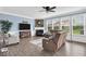 Cozy living room with a fireplace, large windows, neutral paint, and comfortable seating at 10515 Sugar Ridge Way, Indianapolis, IN 46239