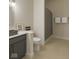 Well-lit bathroom featuring a vanity with a gray countertop, toilet, and glass-enclosed shower at 10655 E 200 S, Zionsville, IN 46077