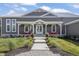 Charming front porch with red chairs, white columns, double doors, and manicured landscaping at 10655 E 200 S, Zionsville, IN 46077