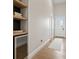 Bright hallway with light hardwood floors and a built in dry bar with a wine cooler at 10655 E 200 S, Zionsville, IN 46077