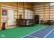 Indoor pickleball court with a bar, lounge furniture, and garage door at 10655 E 200 S, Zionsville, IN 46077